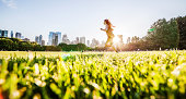 Girl runs in front of Manhattan skyline in Central Park创意图片素材 - E+