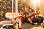 Happy parents reading a book with their small kids.创意图片素材 - E+