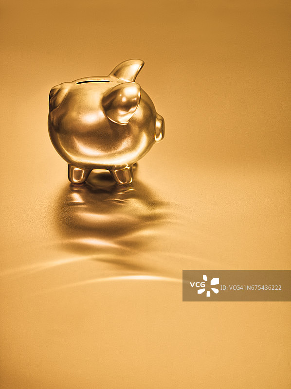 Gold piggy bank on metal background Gold piggy bank on metal background创意图片素材 - Corbis RF