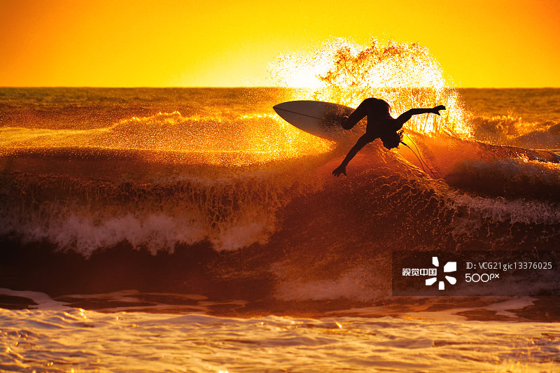 Silhouette of surfer on wave