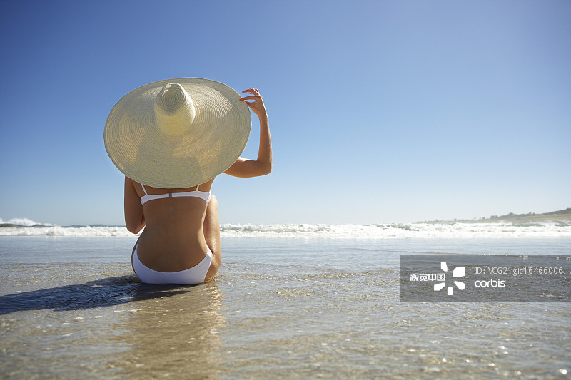 Woman Wearing Sun Hat Sitting on Beach