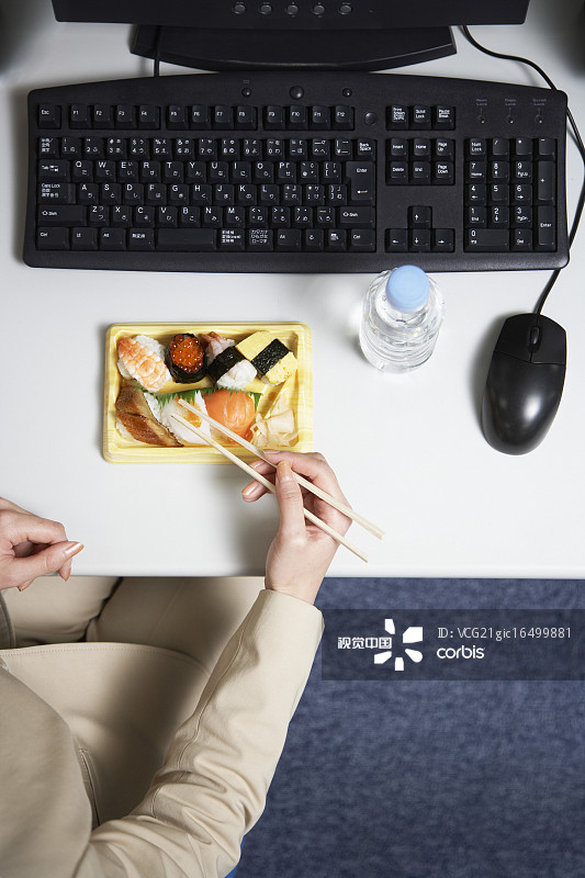 Businesswoman Eating Sushi at Desk