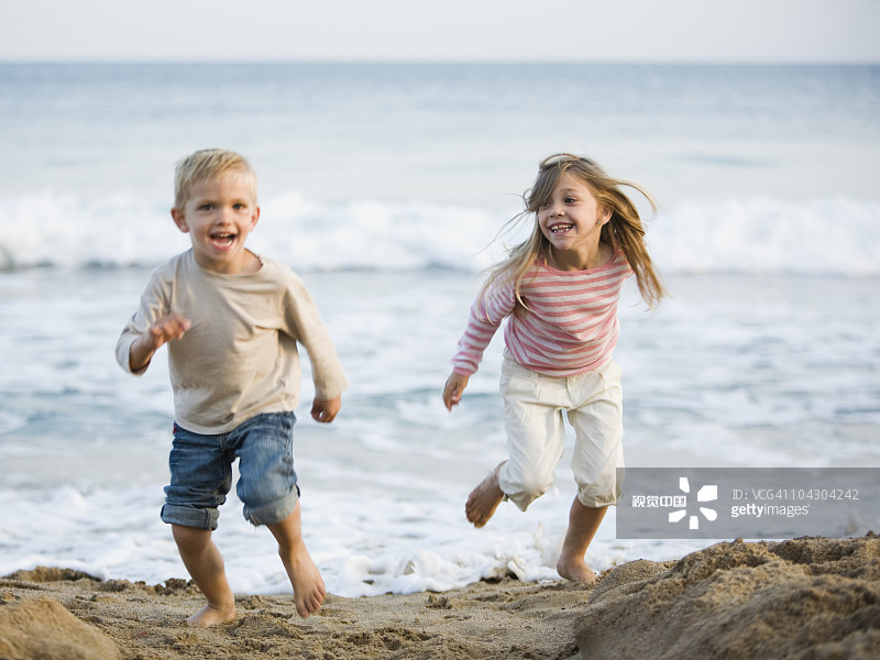 brother and sister running at the beach brother and sister running at the beach创意图片素材 - Brand X Pictures
