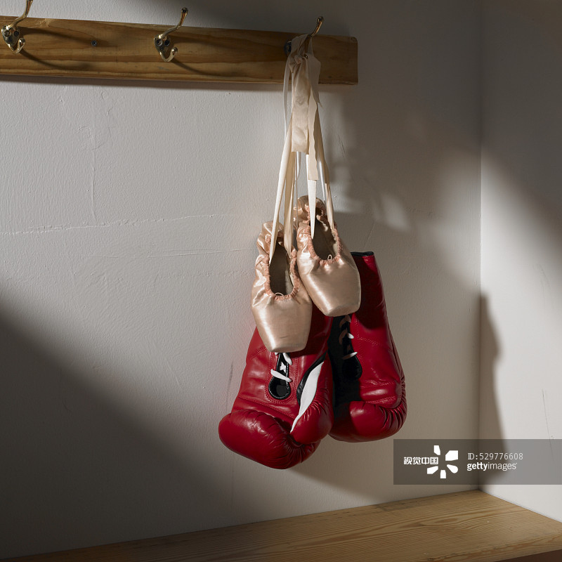 Boxing gloves and ballet shoes hanging in dressing room Boxing gloves and ballet shoes hanging in dressing room创意图片素材 - Corbis RM