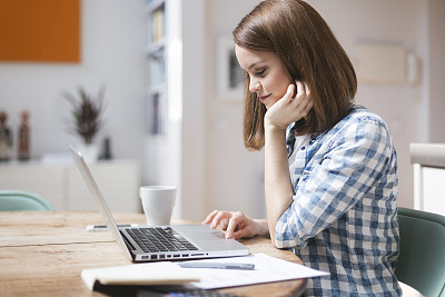 Working at home with wireless technology and laptop.åæå¾çç´ æ - E+