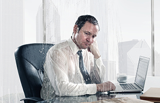 Rain falling on sad business man sitting at desk in office corbis图片素材