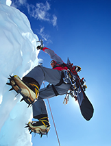 A mountaineer ice climbing with his snowboard for the ride down. corbis圖片素材