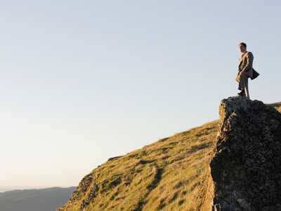 Businessman standing on rock overlooking ocean gettyimages图片素材