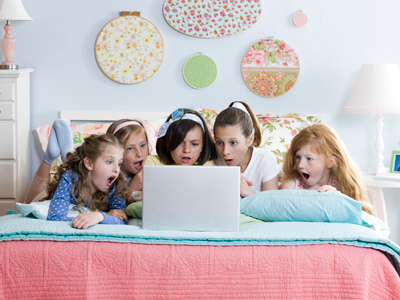 five girls on a bed using a laptop gettyimages圖片素材