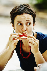 Woman taking bite of pizza during backyard dinner gettyimages图片素材