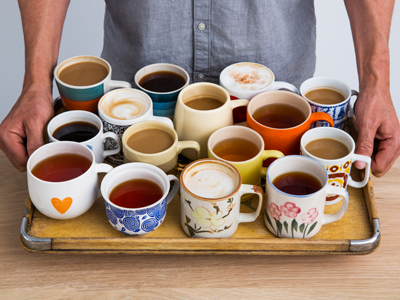 Man holding a tray of many cups of coffee and tea gettyimages圖片素材