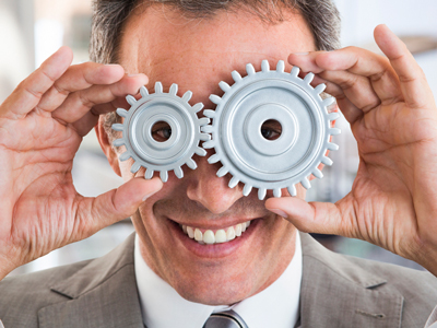 Business man holding cogs to his eyes gettyimages圖片素材