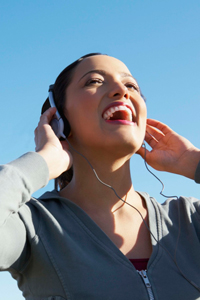 Laughing woman listening to headphones gettyimages图片素材