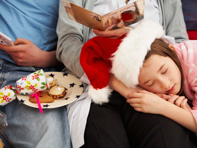 Girl sleeping on mother's lap on Christmas gettyimages图片素材