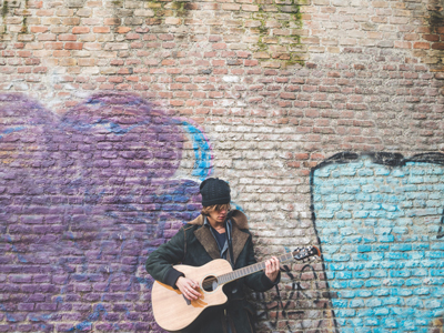 Musician playing guitar by canal wall, Milan, Italy gettyimages圖片素材