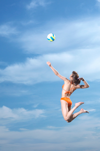 Young woman hitting volley ball jumping in sky gettyimages图片素材